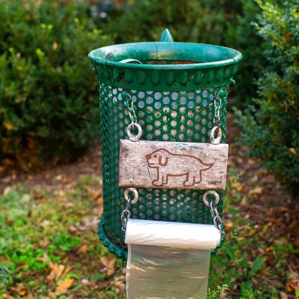 Trash can with a picture of a dog and bags for excrement